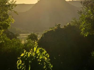 Paisaje de verano con atardecer dorado y montañas en Nono, Argentina.