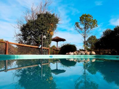 Piscina Posada Nono: oasis relax, sierras, cabañas, cielo azul.